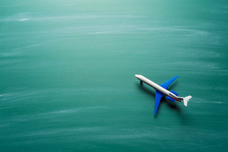 toy airplane over chalkboard backgroundの写真素材