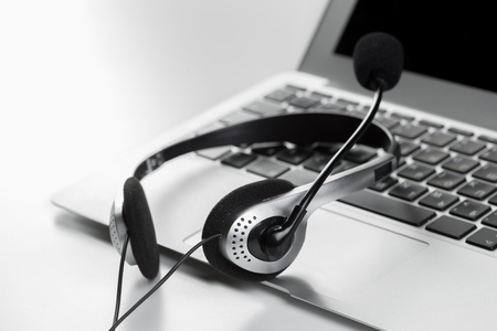 call center support concept. headset on keyboard computer laptopの写真素材