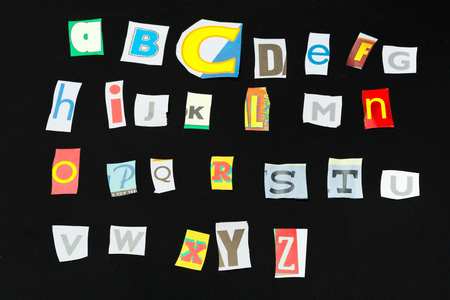 Colorful newspaper alphabet isolated on blackの写真素材