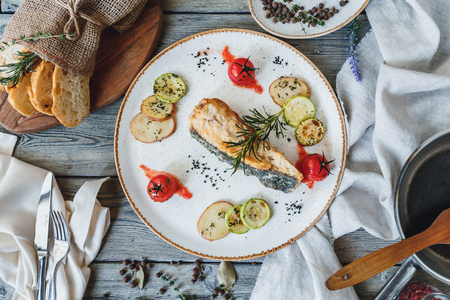 Baked salmon with sauce and spices on a white plateの写真素材
