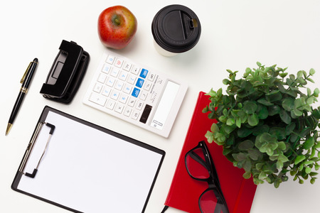 Flat lay of working space supplies on white table