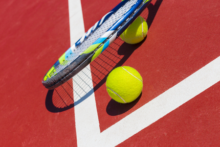 Tennis balls and racket on the grass courtの写真素材
