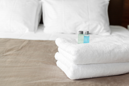 White towel on bed in guest room for hotel customerの写真素材
