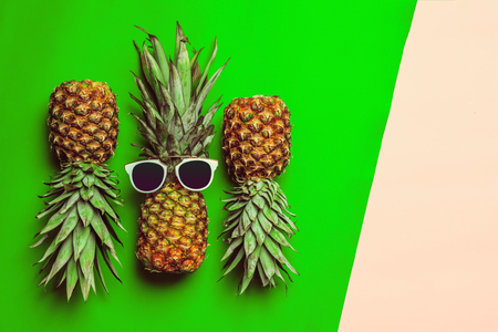 pineapple on colored paper with glassesの写真素材