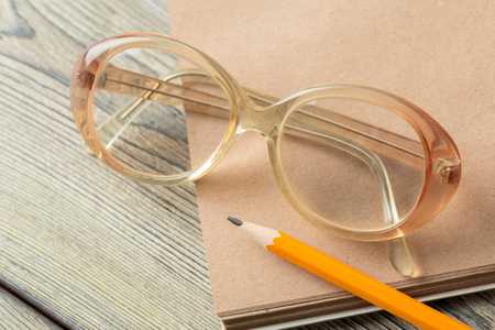 notepad and eyeglasses on the tableの写真素材