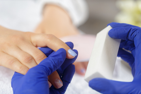Woman hands receiving a manicure in beauty salonの写真素材