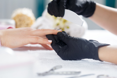 Woman hands receiving a manicure in beauty salonの写真素材