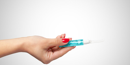 Woman hand with mascara cosmetic tube isolated on color backgroundの写真素材
