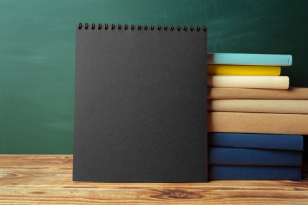 Classroom with blackboard, wooden table and booksの写真素材