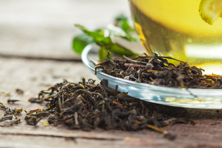 cup of black tea with mint leaves on a wooden tableの写真素材