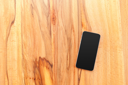 Mobile phone with blank screen mockup on wood table backgroundの写真素材