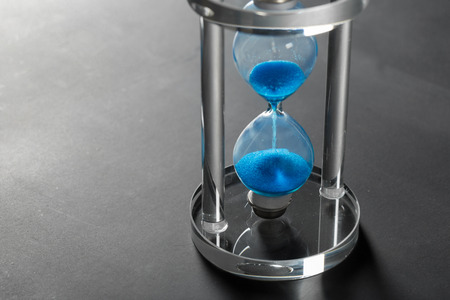 Time is passing. Blue hourglass close upの写真素材
