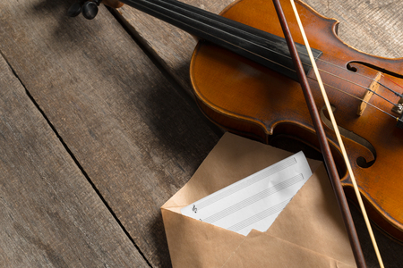 Sheet music and violin on wooden tableの写真素材