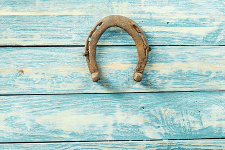 old rusty horseshoes on wooden boardの写真素材