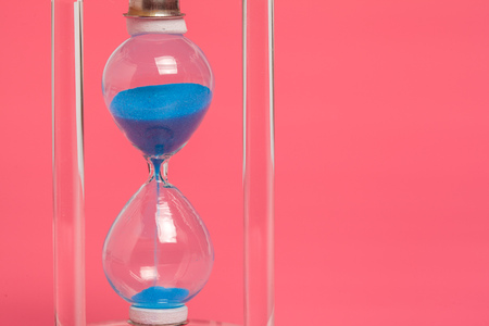 Close up of hourglass against pink background