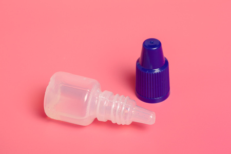Eye drops isolated on pink backgroundの写真素材