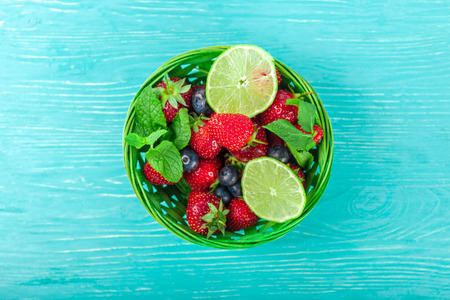 bowl on wooden table, strawberries and blueberries insideの写真素材