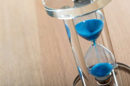 Time is passing. Blue hourglass close up