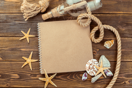 Shells and notepad on wooden table. Top view with copy spaceの写真素材