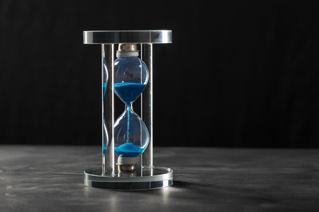 Time is passing. Blue hourglass close up