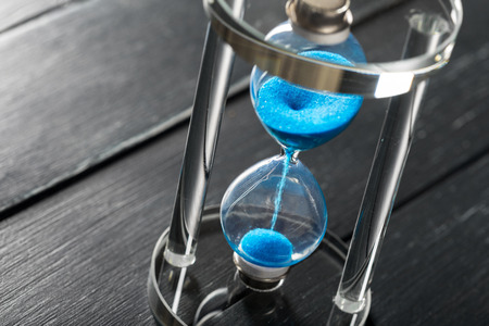 Time is passing. Blue hourglass close up