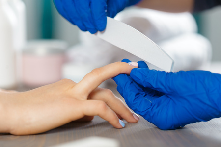 Woman hands receiving a manicure in beauty salonの写真素材