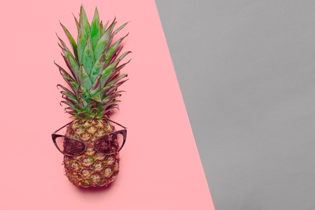 pineapple on colored paper with glassesの写真素材