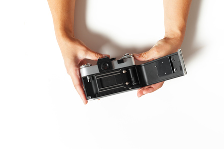 female hands hold vintage camera on white backgroundの写真素材