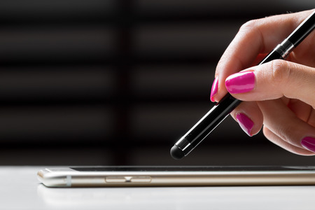 woman working with pen on smart mobile phoneの写真素材