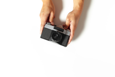 female hands hold vintage camera on white background