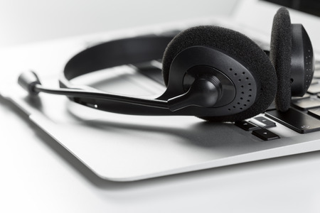 call center support concept. headset on keyboard computer laptopの写真素材