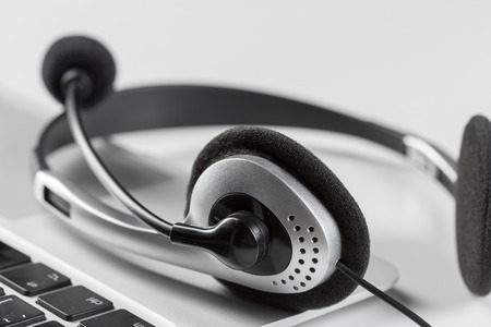 call center support concept. headset on keyboard computer laptop
