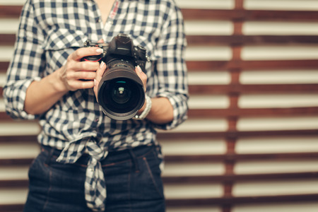 Pretty woman is a professional photographer with dslr cameraの写真素材