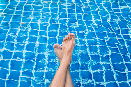 Beautiful woman legs in swimming pool.