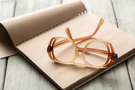 notepad and eyeglasses on the tableの写真素材