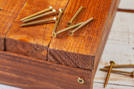 screws on a wooden tableの写真素材