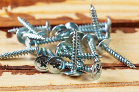 screws on a wooden tableの写真素材