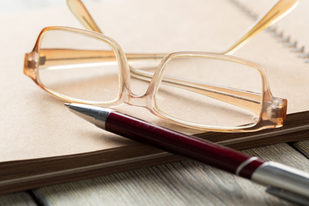 notepad and eyeglasses on the tableの写真素材