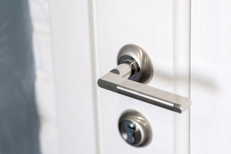 Detail of a metallic knob on white door horizontal