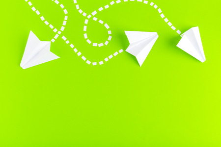 Paper airplanes  connected with dotted lines on green background. Business conceptの写真素材