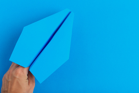 Paper plane on bright background holding in human hand. Travel and tourism conceptの写真素材