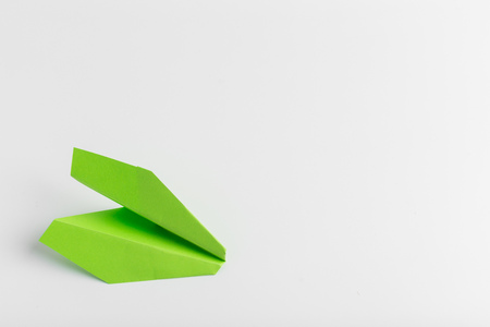 Flat lay of white paper plane on white color backgroundの写真素材