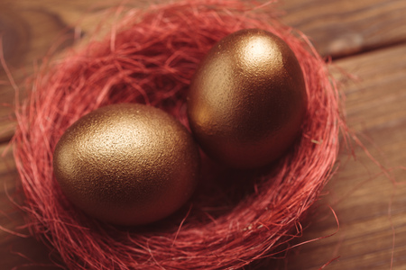 gold eggs on wooden tableの写真素材