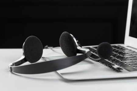 call center support concept. headset on keyboard computer laptopの写真素材