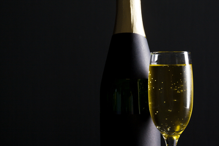 champagne wine glass and bottle on black backgroundの写真素材