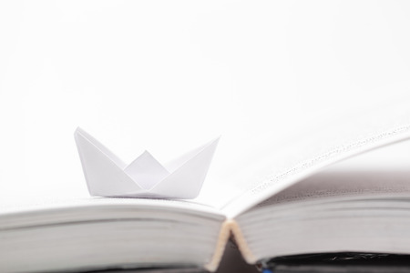 Origami paper boat on a book