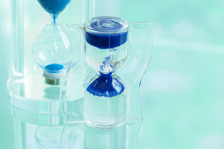 Time passing. Blue hourglass.の写真素材