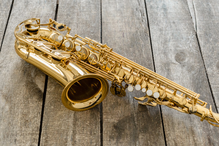 Beautiful golden saxophone on wooden backgroundの写真素材