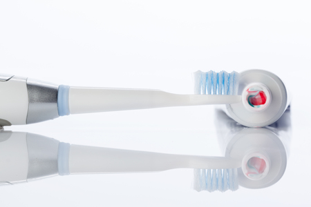Dental brush and tube with paste isolated on whiteの写真素材