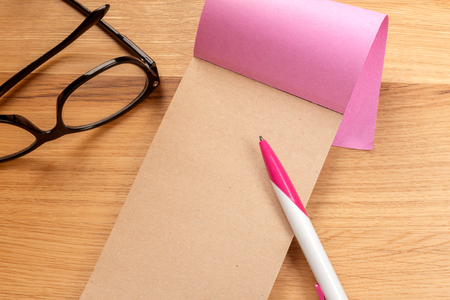 Notepad, pencil and glasses on the wooden backgroundの写真素材